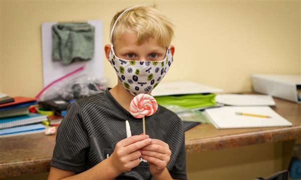 Boy holds up food model made of clay